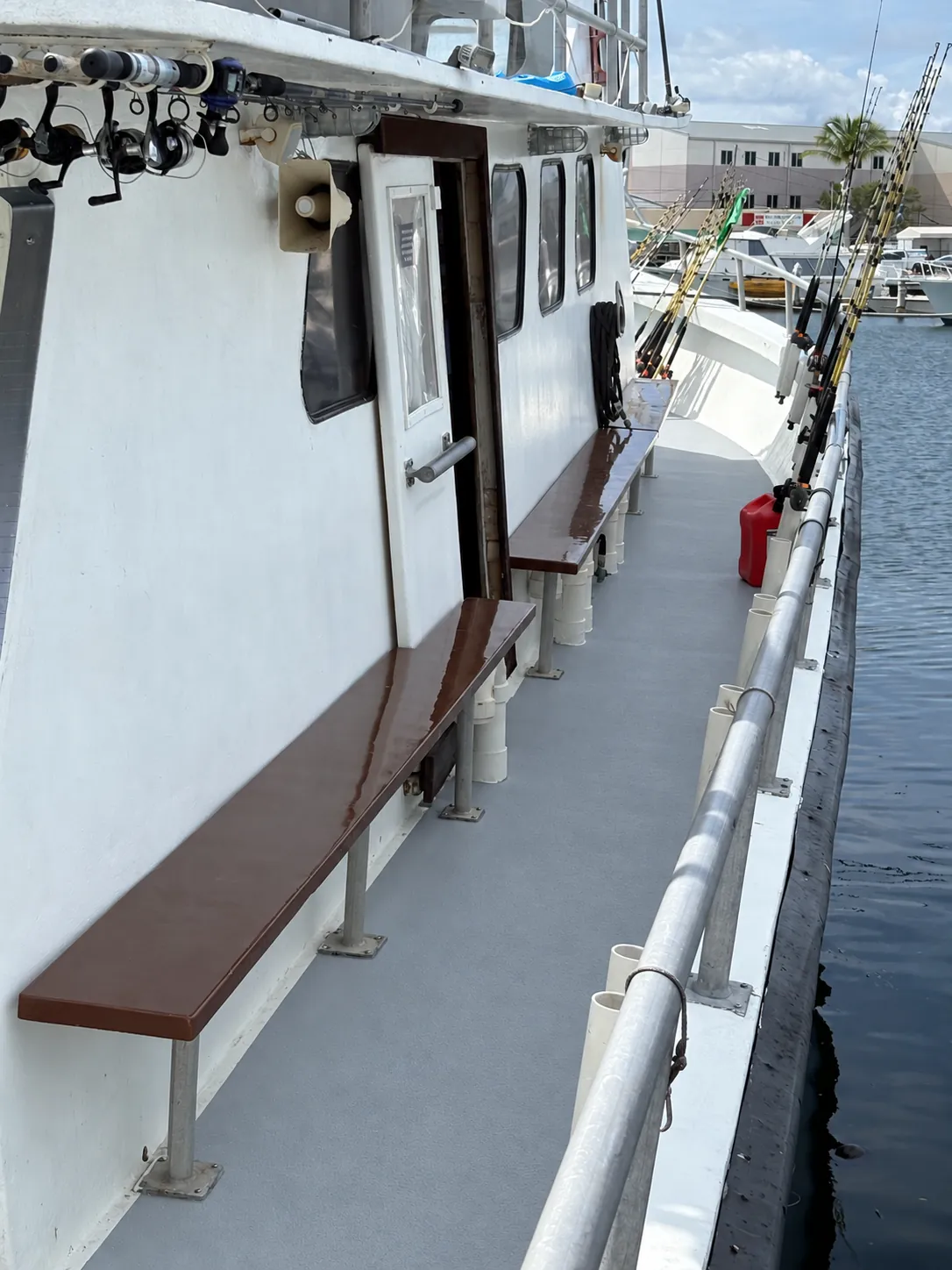 Side deck with bench seating and rod holders aboard the Gulfstream IV Key West party boat